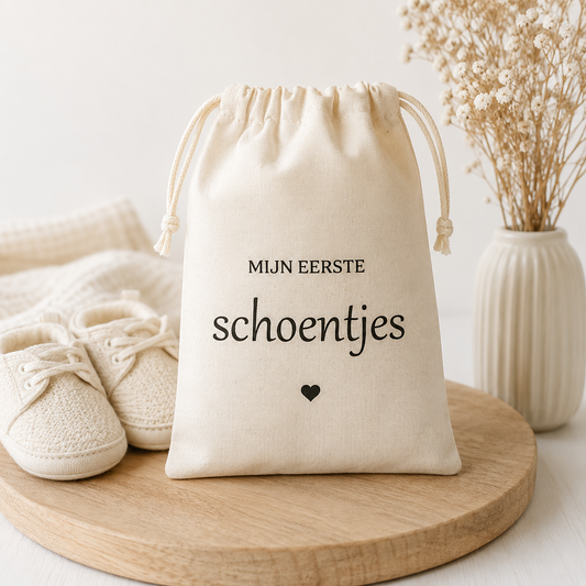 Een katoenen zakje met opdruk Mijn eerste schoentjes! te geven als kraamcadeau en bij een babyshower